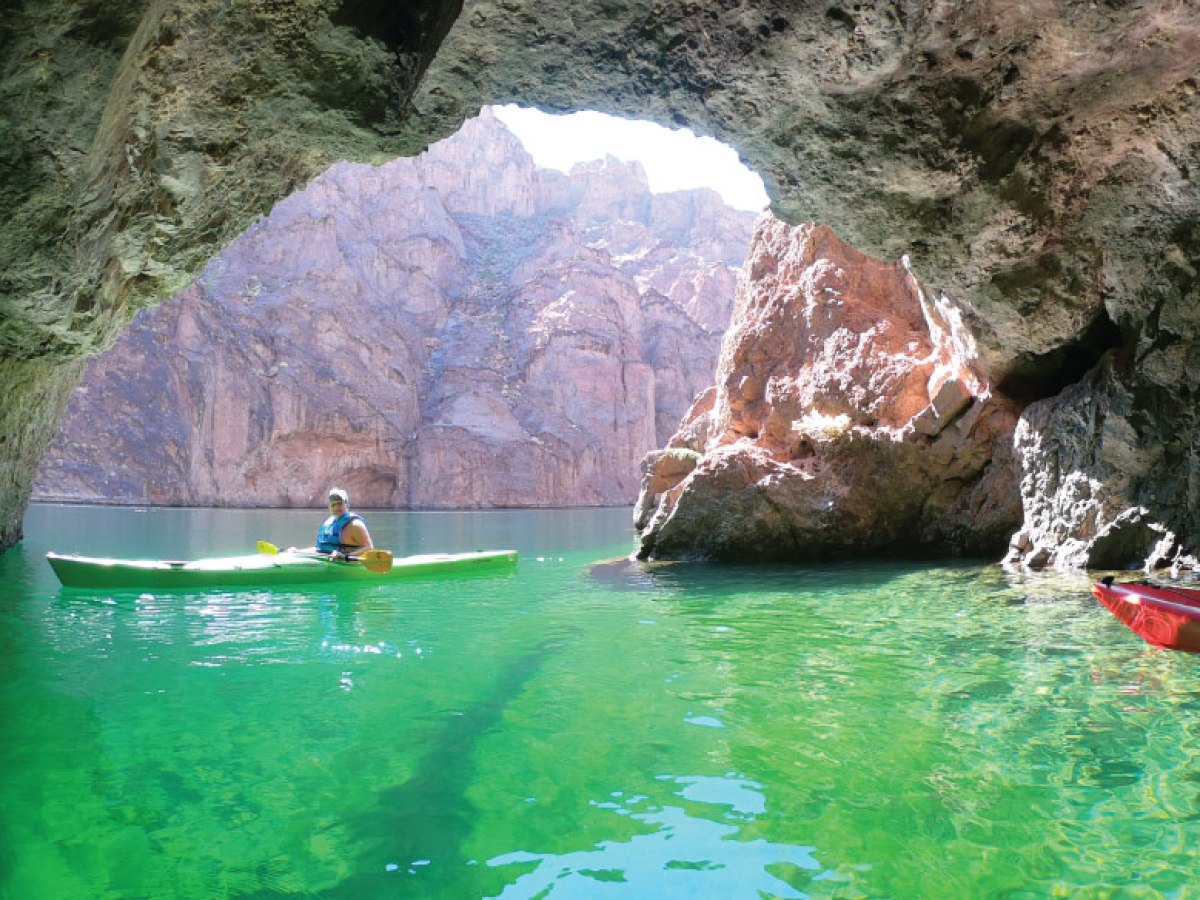 a person swimming in the water with a mountain in the background